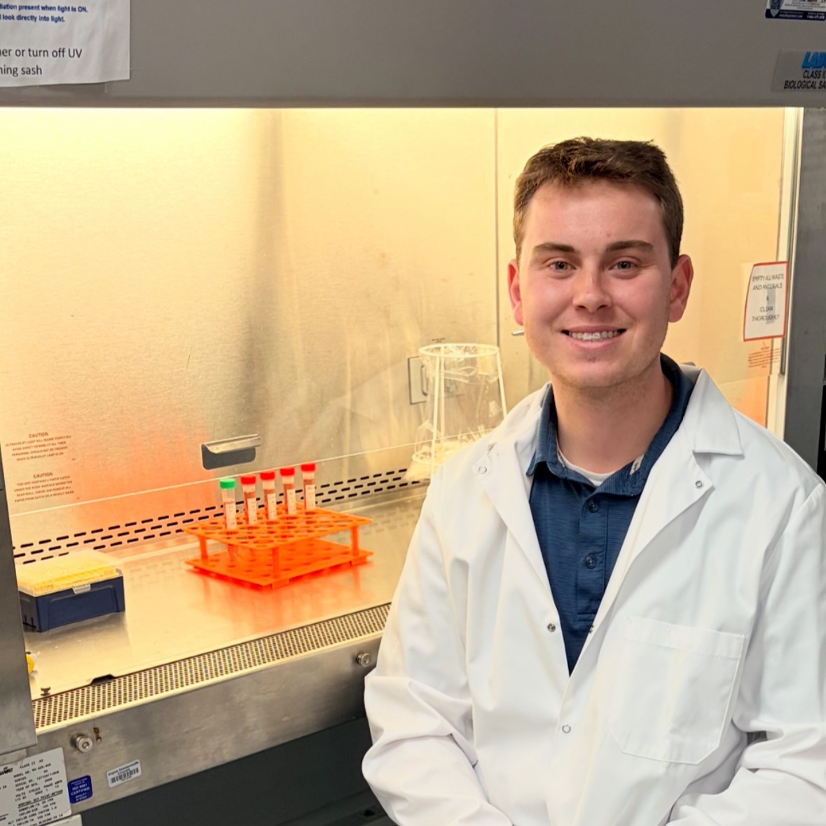 Alex Counts smiling in front of lab