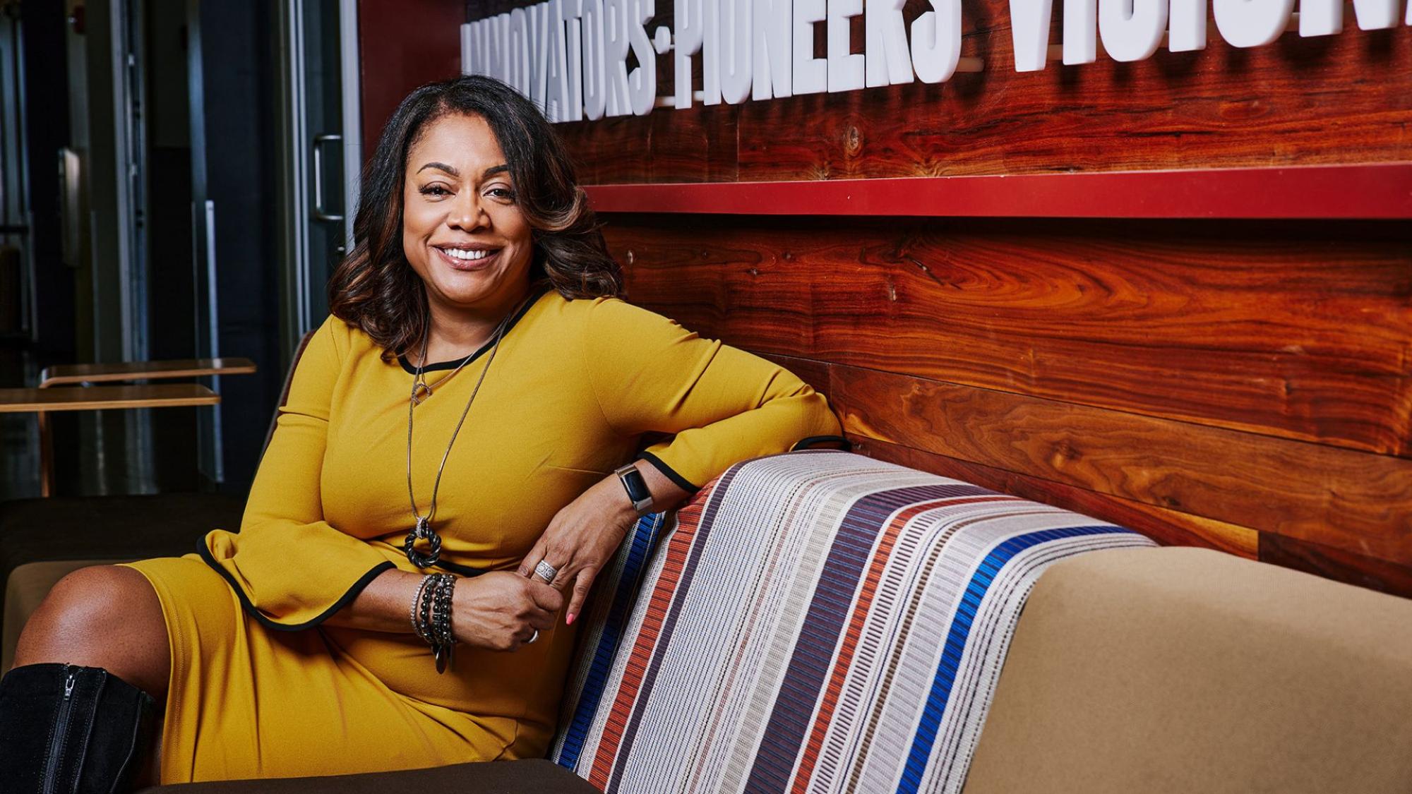 Lisa Pinkney sitting on a couch smiling